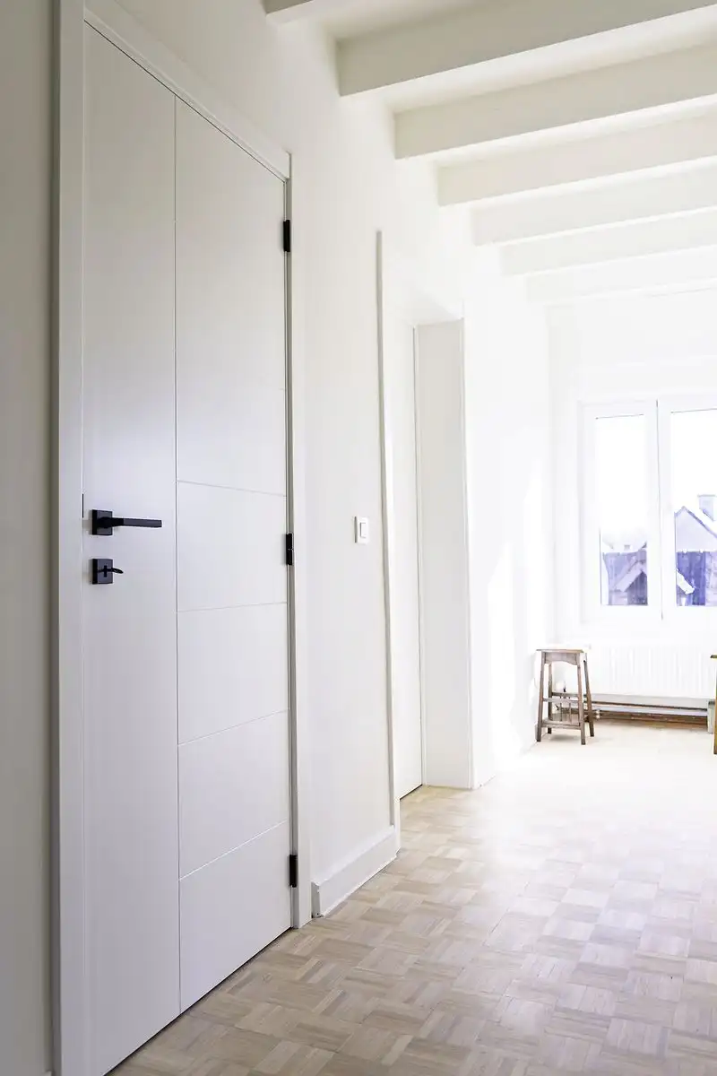 Combinatie van strak gelakte deuren met de warmte van hout in een gerenoveerde vierkantshoeve in Nederhasselt, gemaakt en geplaatst door Jacobs Binnendeuren